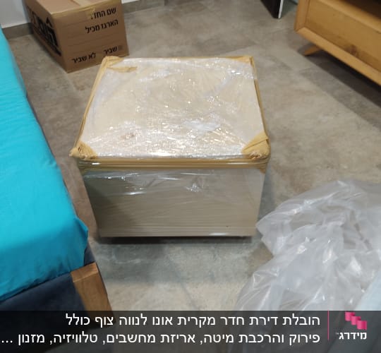 קופסה עטופה בניילון, קרטון אריזה, גליל ניילון על הרצפה